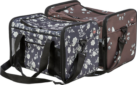 Transporttasche mit Blumenmuster und Gesichtsmotiven, schwarze Tragegriffe, mehrere Reißverschlüsse, Netzseitenteile.