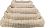 Beige, flauschige Stoffringe in absteigender Größe stapeln sich in Pyramidenform.