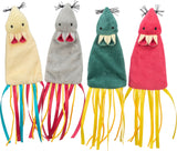 Vier bunte Stoffspielzeuge in Form von Tintenfischen mit baumelnden Bändern, Farben sind Gelb, Grau, Grün und Rot.