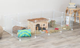 Weißer Laufstall mit Holzhütte, Heu, Wasserflasche, Spielsachen und einem Tier auf Holzfußboden.