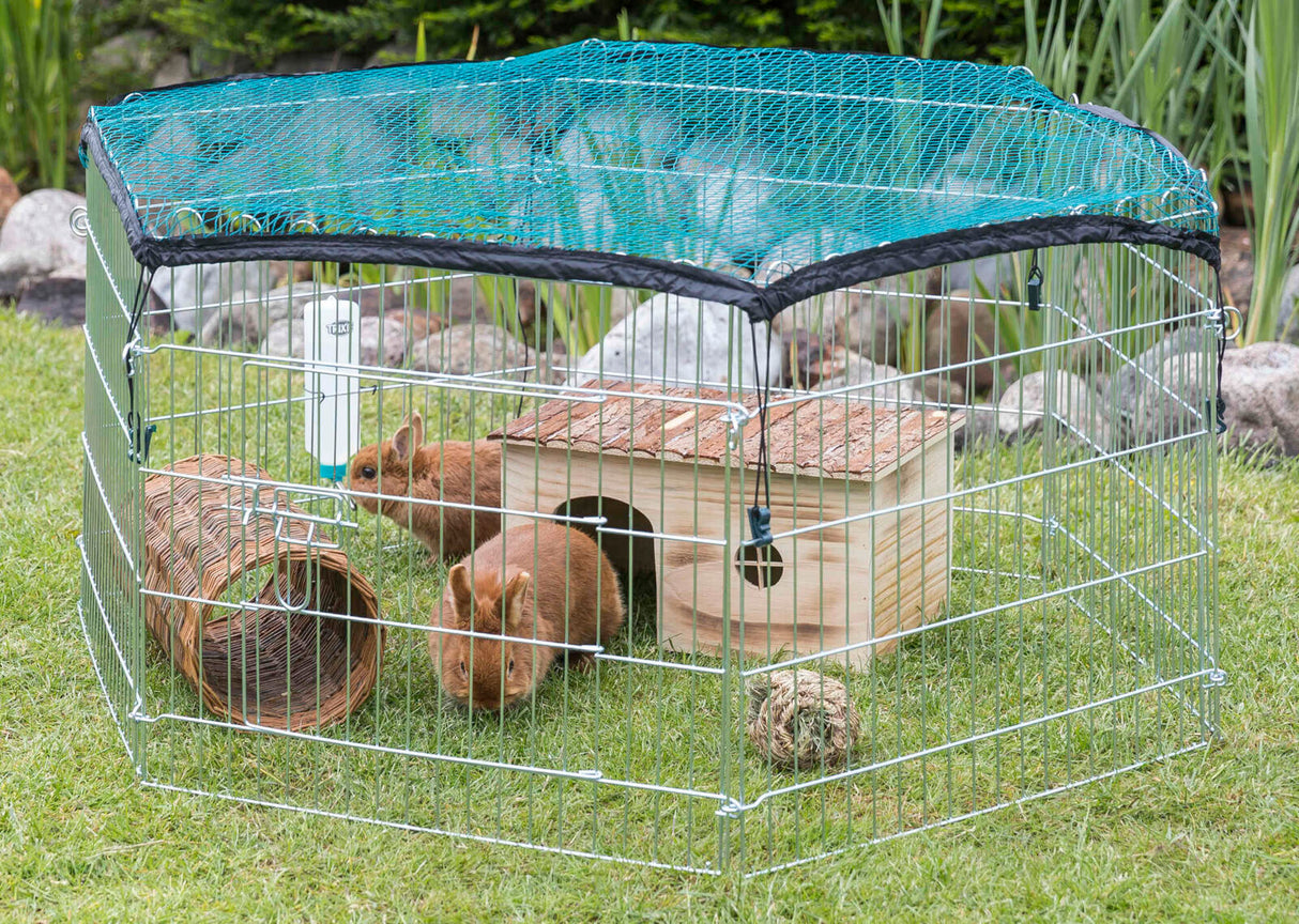 Drahtgehege mit grünem Netz für Kleintiere auf Gras, enthält zwei Kaninchen, Holzhaus und Weidentunnel.