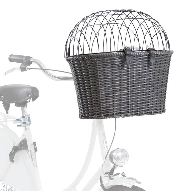 Ein schwarzer Fahrradkorb aus Korbgeflecht mit Metallkäfigabdeckung ist am Lenker eines weißen Fahrrads befestigt.