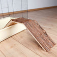 Holzrampe mit Struktur auf hellem Holzboden neben einem Gitterkäfig mit beige Bodenwanne.