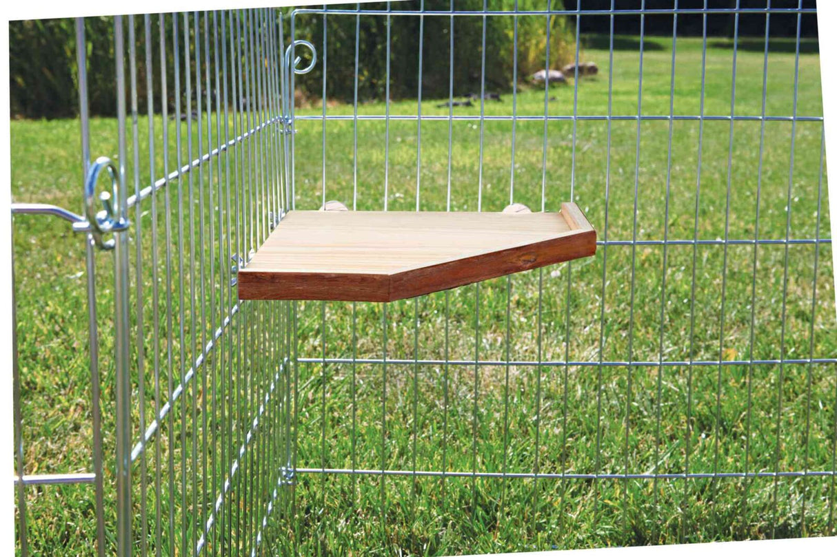 Holzplattform an einem Drahtgitterzaun vor einer grünen Rasenfläche im Freien befestigt.