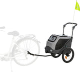 Fahrradanhänger mit zwei Rädern, grauem Gehäuse und gelber Fahne, zeigt Verbindung zu einem Fahrrad.