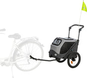 Fahrradanhänger mit zwei Rädern, grauem Gehäuse und gelber Fahne, zeigt Verbindung zu einem Fahrrad.