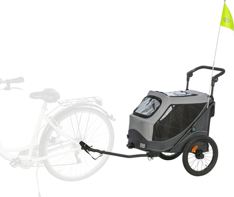 Ein grauer Fahrradanhänger mit schwarzem Netzstoff und gelber Fahne ist an einem weißen Fahrrad angebracht.