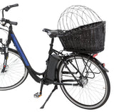 Schwarzes Fahrrad mit großem, dunklem Korb auf dem Gepäckträger und gebogenem Metallgitter oben, Seitenansicht.