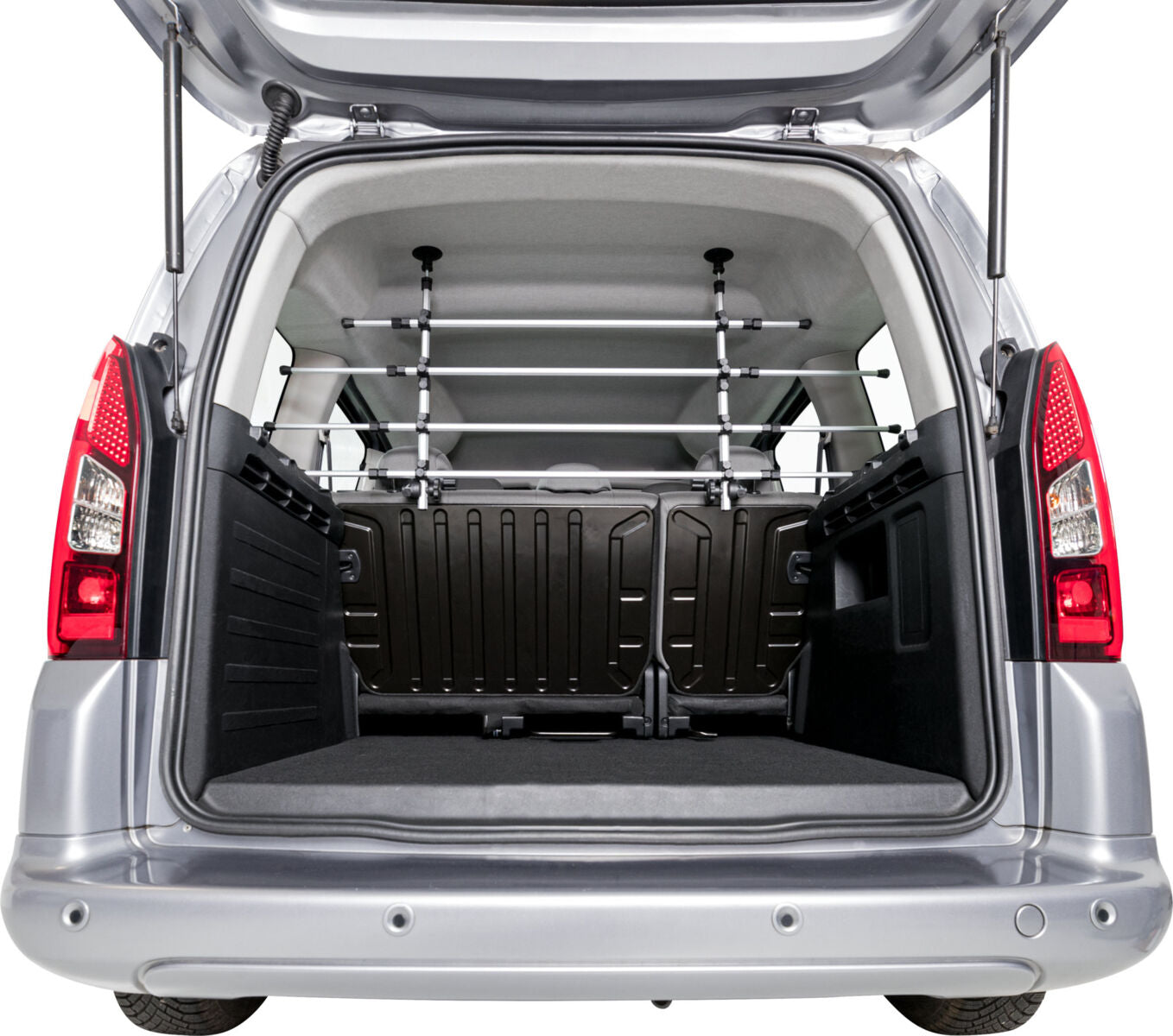 Der geöffnete Kofferraum eines silbernen Fahrzeugs mit einer schwarzen Trennwand und Metallstäben.