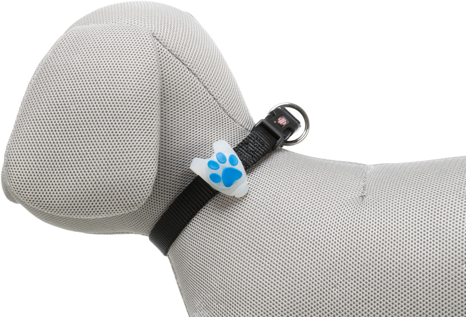Ein graues Stoffmodell eines Hundes trägt ein schwarzes Halsband mit einem weißen Clip, der blaue Pfotenabdrücke zeigt.