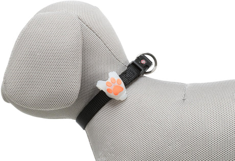 Graues, stoffbezogenes Hundemodell mit schwarzem Halsband, darauf ein weißer Anhänger mit orangefarbener Pfotenform.