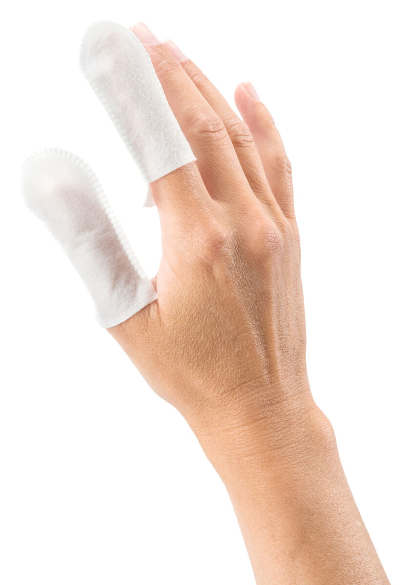 Eine Hand mit zwei Fingern in weißen Fingerhülsen, die leicht transparent sind, auf weißem Hintergrund.