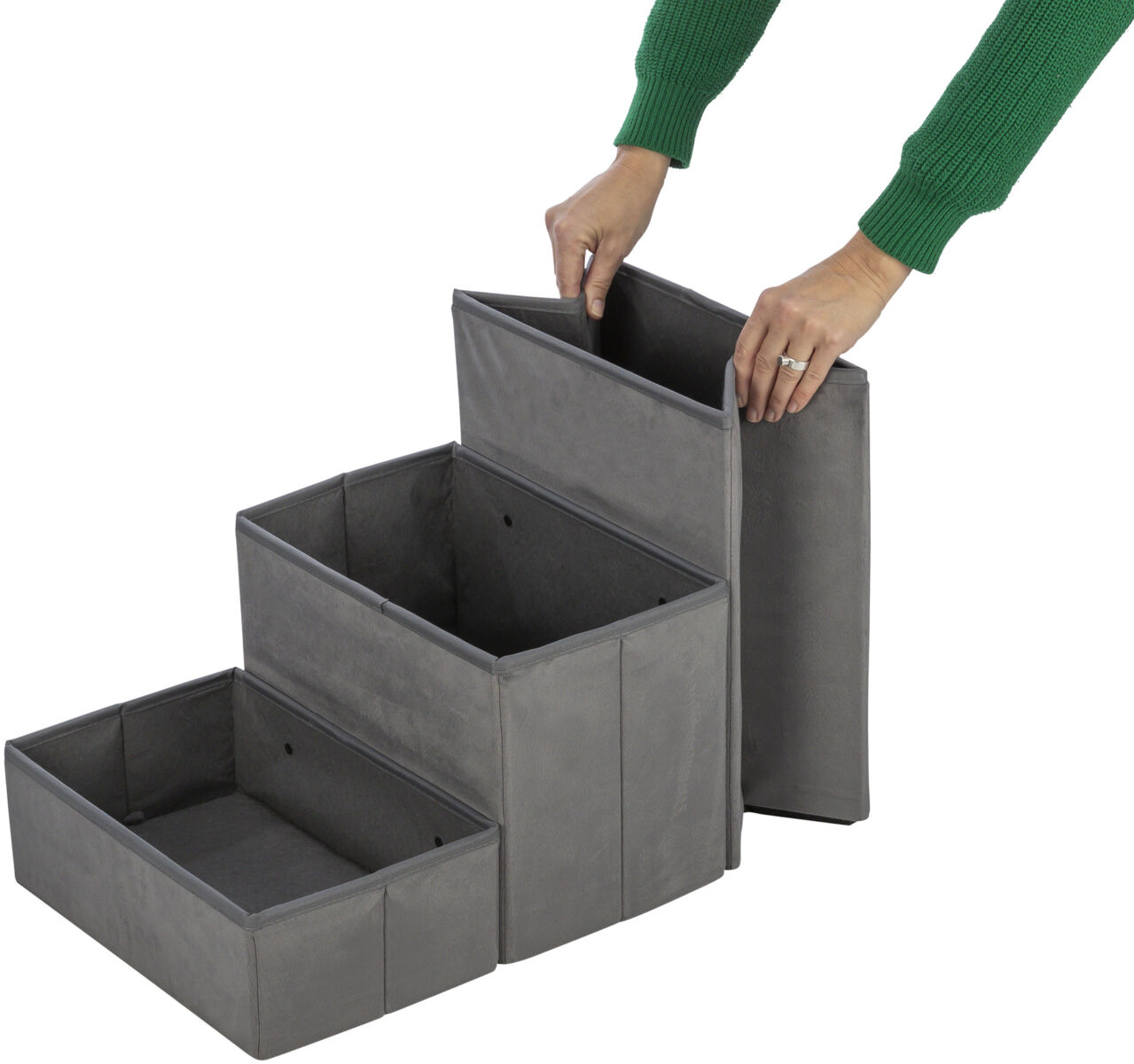 Graue, dreistufige faltbare Aufbewahrungsbox aus Stoff mit einer Person, die die oberste Stufe anhebt.