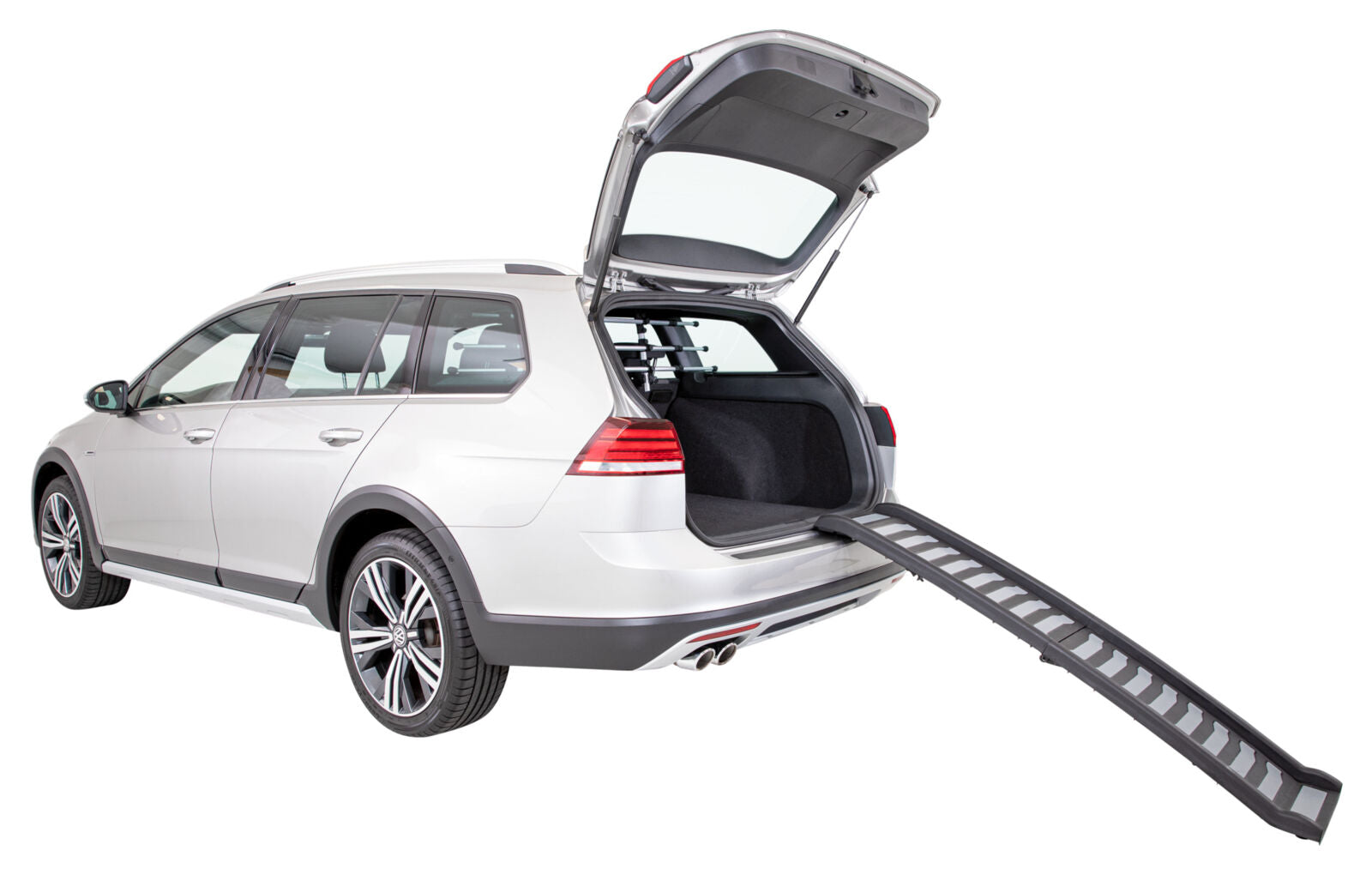 Ein silberner Kombi mit offener Heckklappe und einer Rampe, die vom Laderaum zum Boden führt, auf weißem Hintergrund.