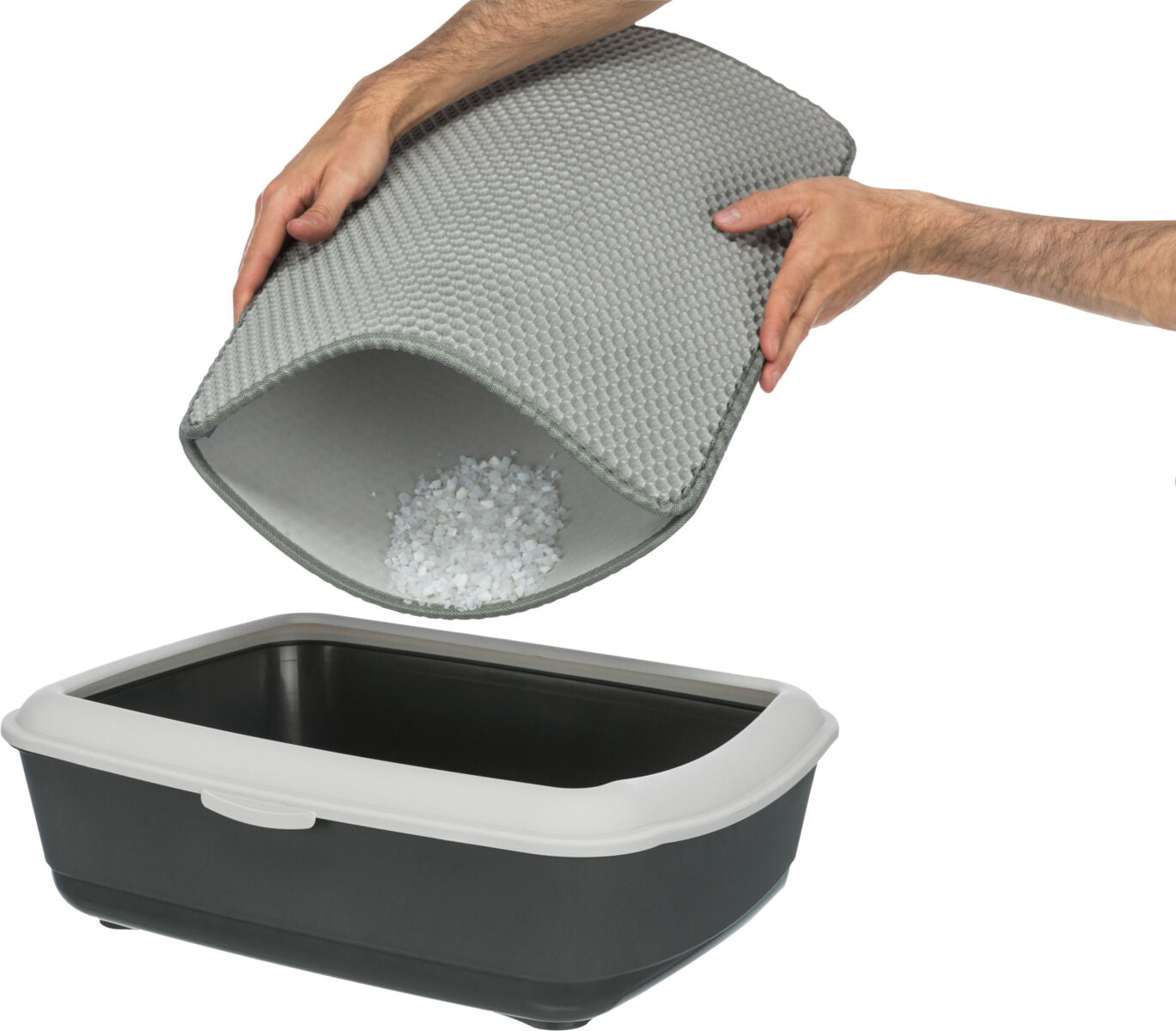 Eine Hand hält eine graue Matte über einer offenen Katzentoilette, während darin Streu ausgeschüttet wird.