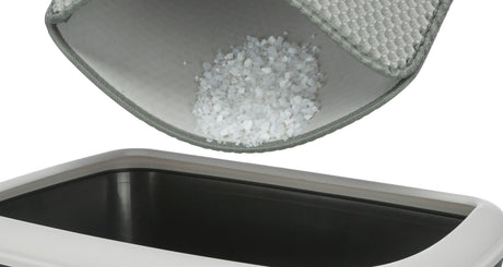 Ein Behälter mit einem grauen Filter darüber, aus dem weiße Granulatstücke heraus rieseln.