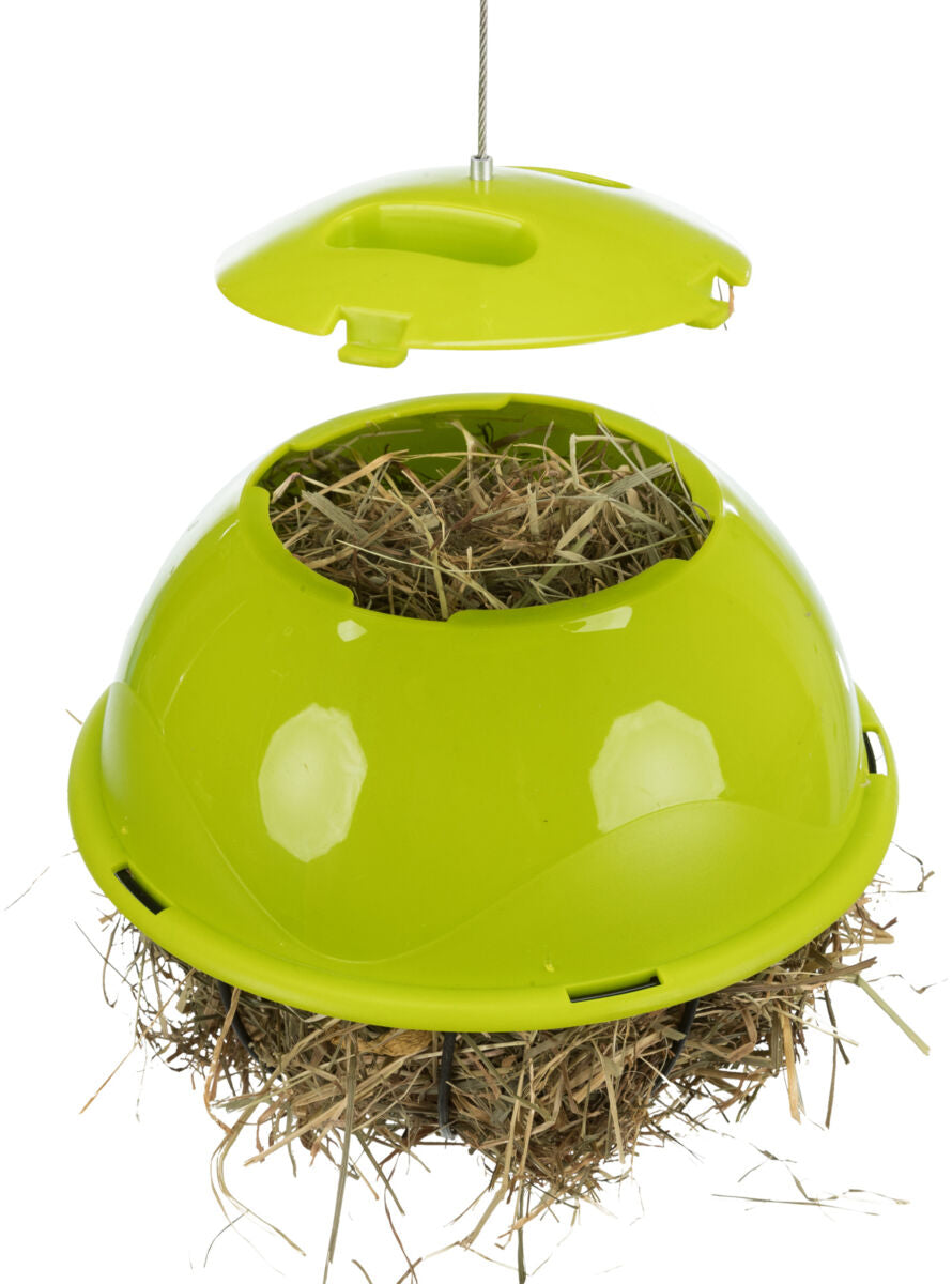 Grüne, kugelförmige Futterstation mit abnehmbarem Deckel, gefüllt mit Stroh, an einem Drahtseil hängend.